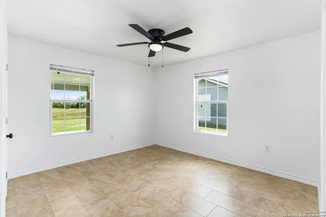 an empty room with closet and a ceiling fan
