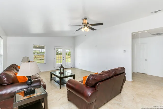 a living room with furniture a air conditioner vent and a window