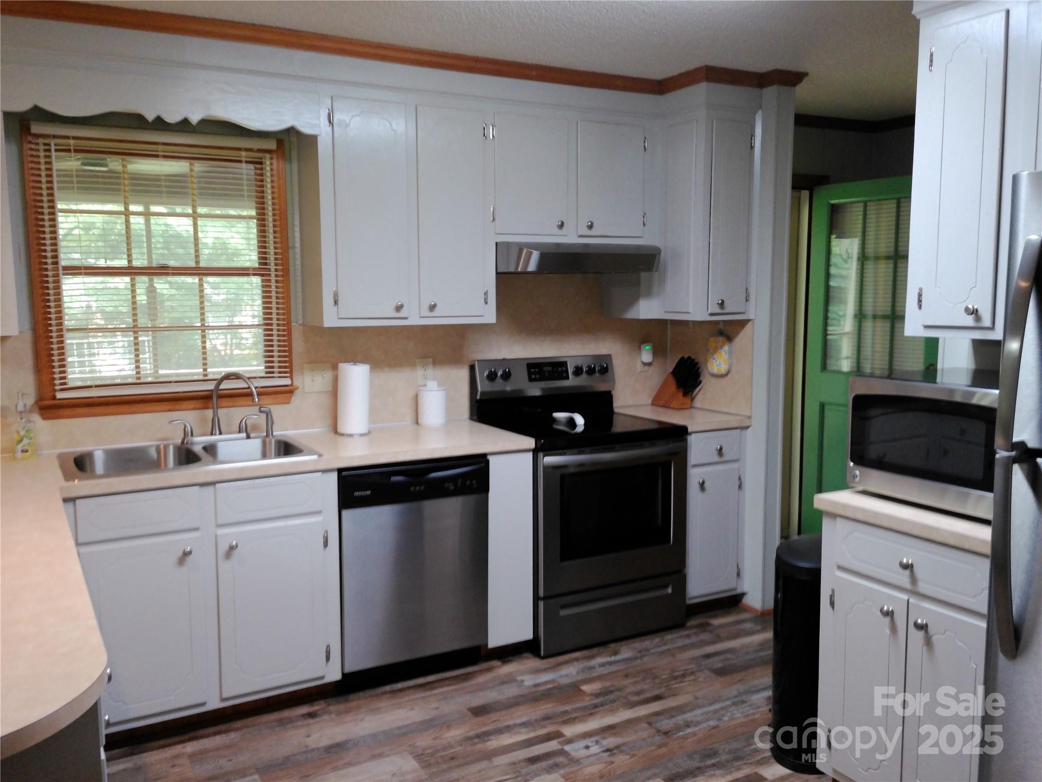 216 Williams Road Harrisburg, NC 28075 - Photo 11 of 28 a kitchen with white cabinets and appliances