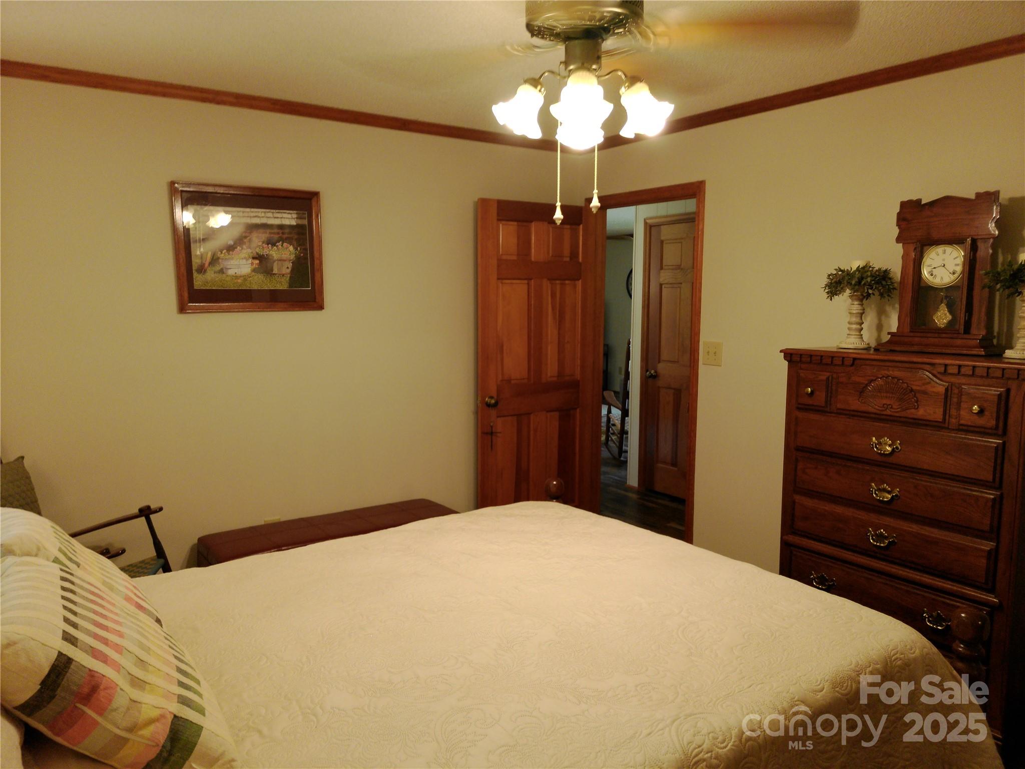 216 Williams Road Harrisburg, NC 28075 - Photo 19 of 28 a bedroom with a bed and a chandelier