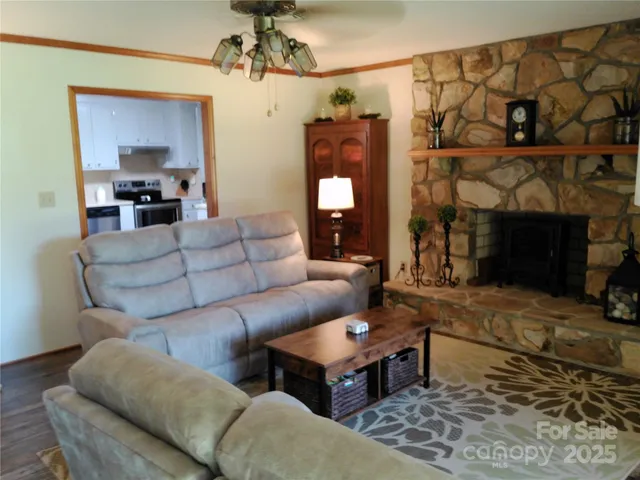 a living room with furniture a fireplace and a chandelier
