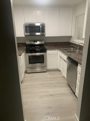 a kitchen with granite countertop a stove and a microwave