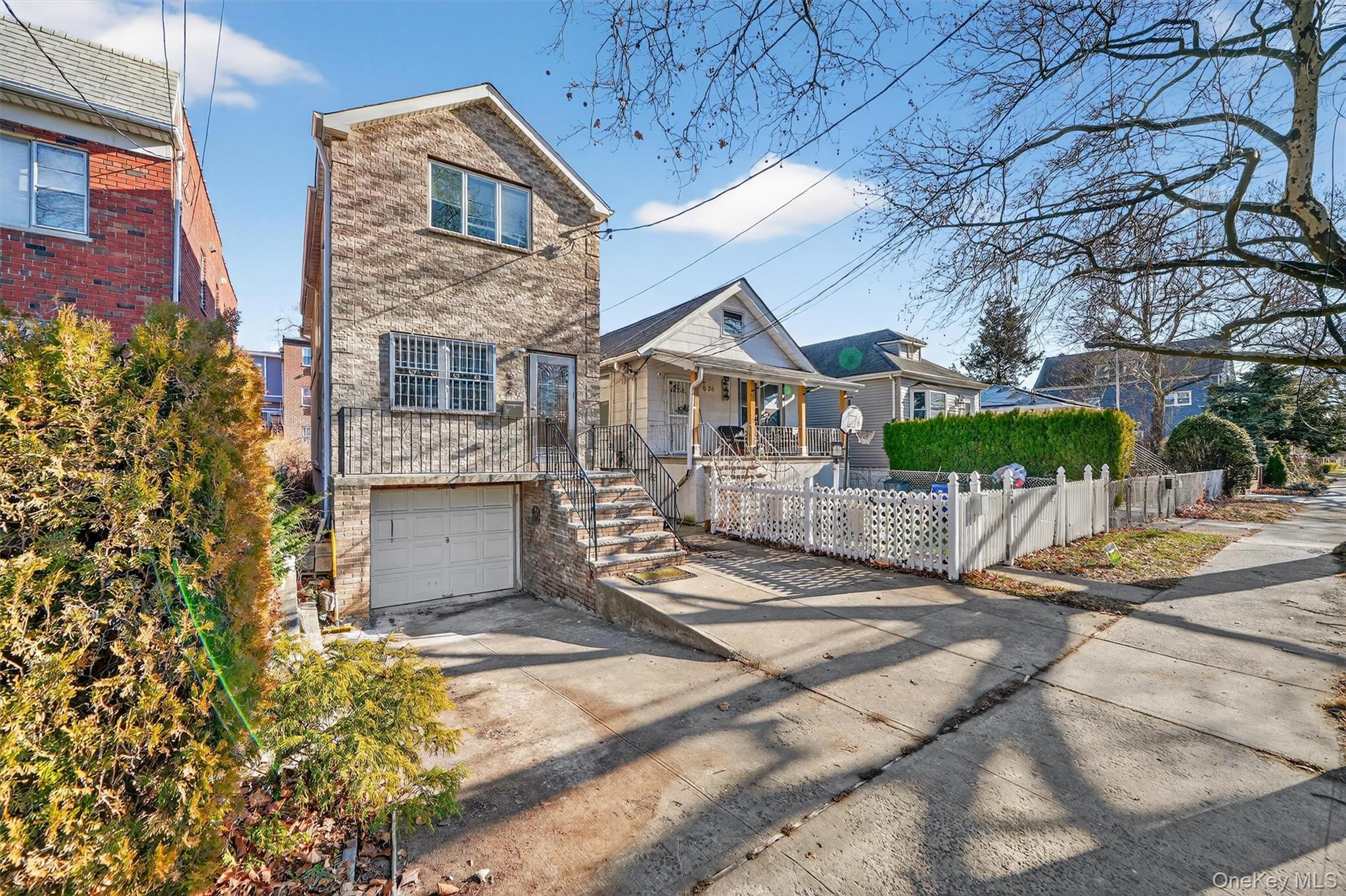 636 Throgs Neck Expressway Bronx, NY 10465 - Photo 1 of 31 View of front of home featuring driveway, a fenced front yard, a garage, stairs, and covered porch