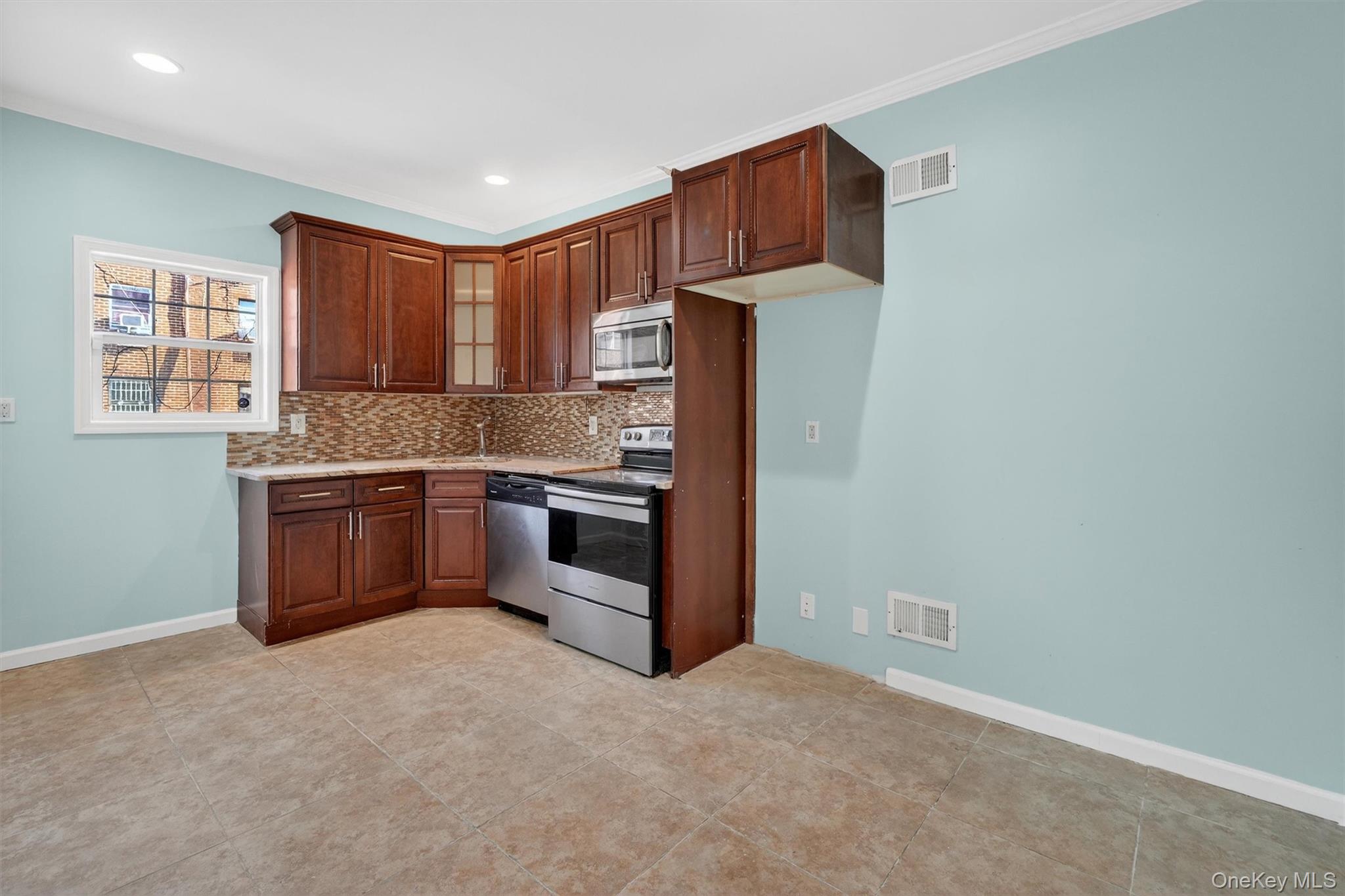 636 Throgs Neck Expressway Bronx, NY 10465 - Photo 11 of 31 Kitchen with stainless steel appliances, tasteful backsplash, glass insert cabinets, light tile patterned flooring, and light stone countertops