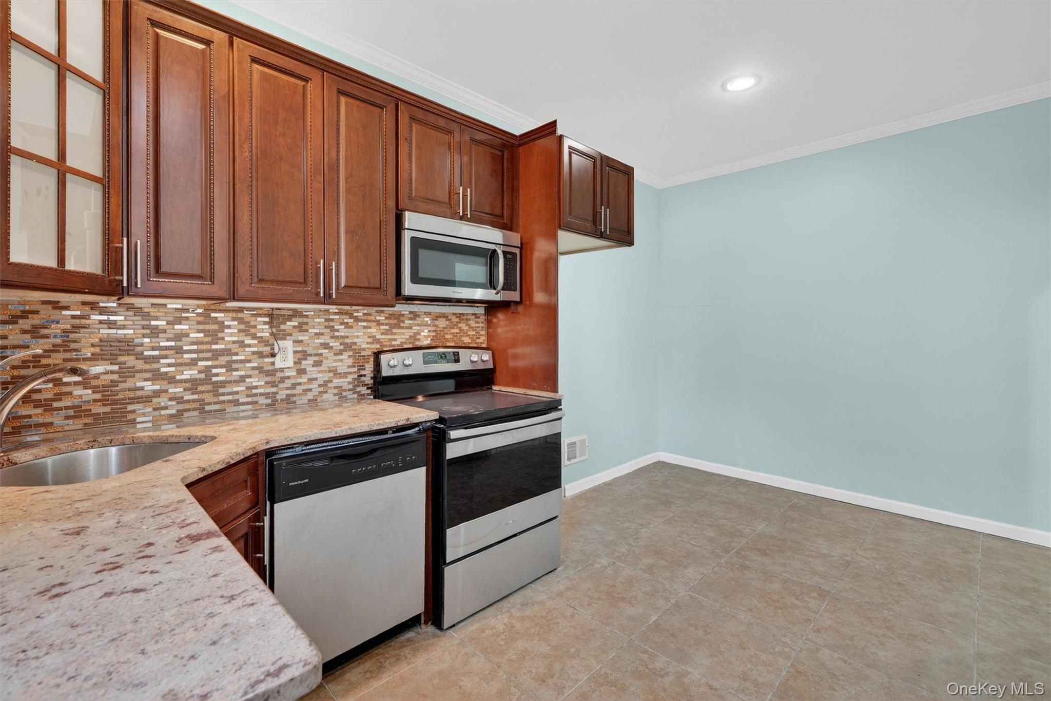 636 Throgs Neck Expressway Bronx, NY 10465 - Photo 15 of 31 Kitchen with stainless steel appliances, light stone countertops, crown molding, tasteful backsplash, and recessed lighting