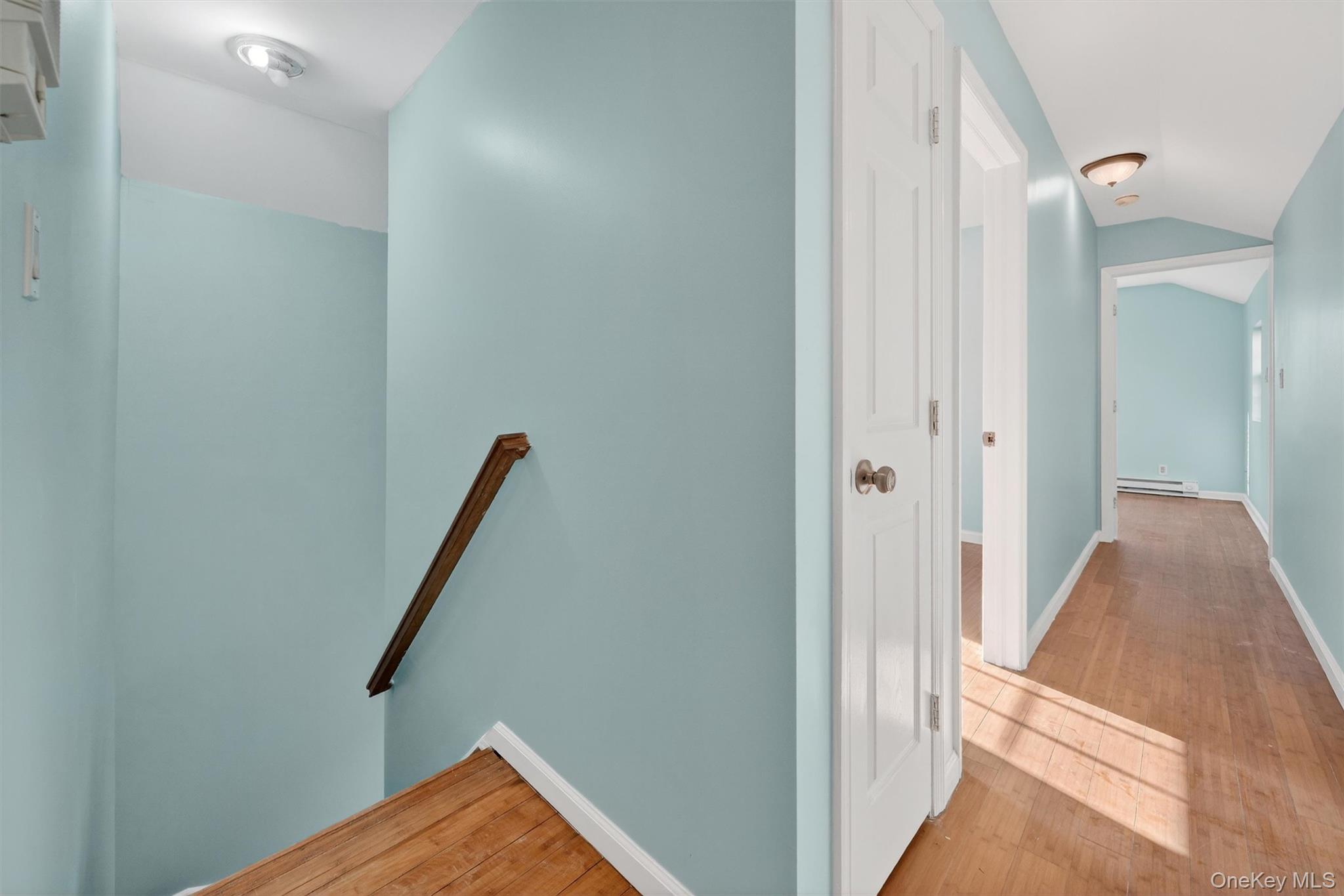 636 Throgs Neck Expressway Bronx, NY 10465 - Photo 18 of 31 Hall with an upstairs landing, light wood-type flooring, vaulted ceiling, and a baseboard heating unit