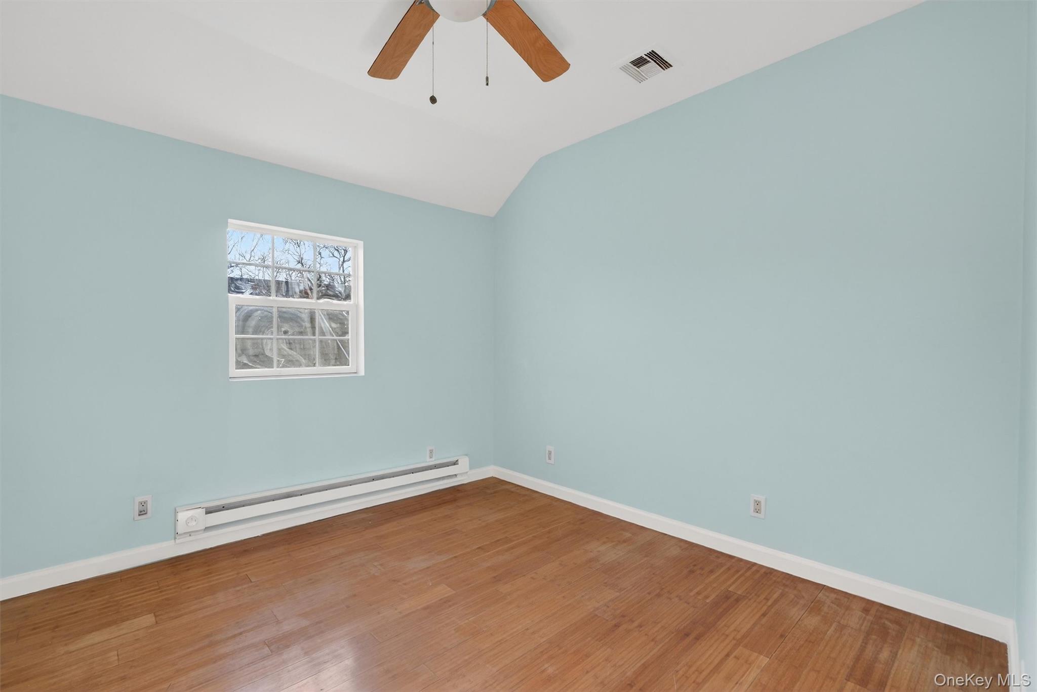 636 Throgs Neck Expressway Bronx, NY 10465 - Photo 20 of 31 Unfurnished room featuring a baseboard heating unit, hardwood / wood-style floors, lofted ceiling, and a ceiling fan