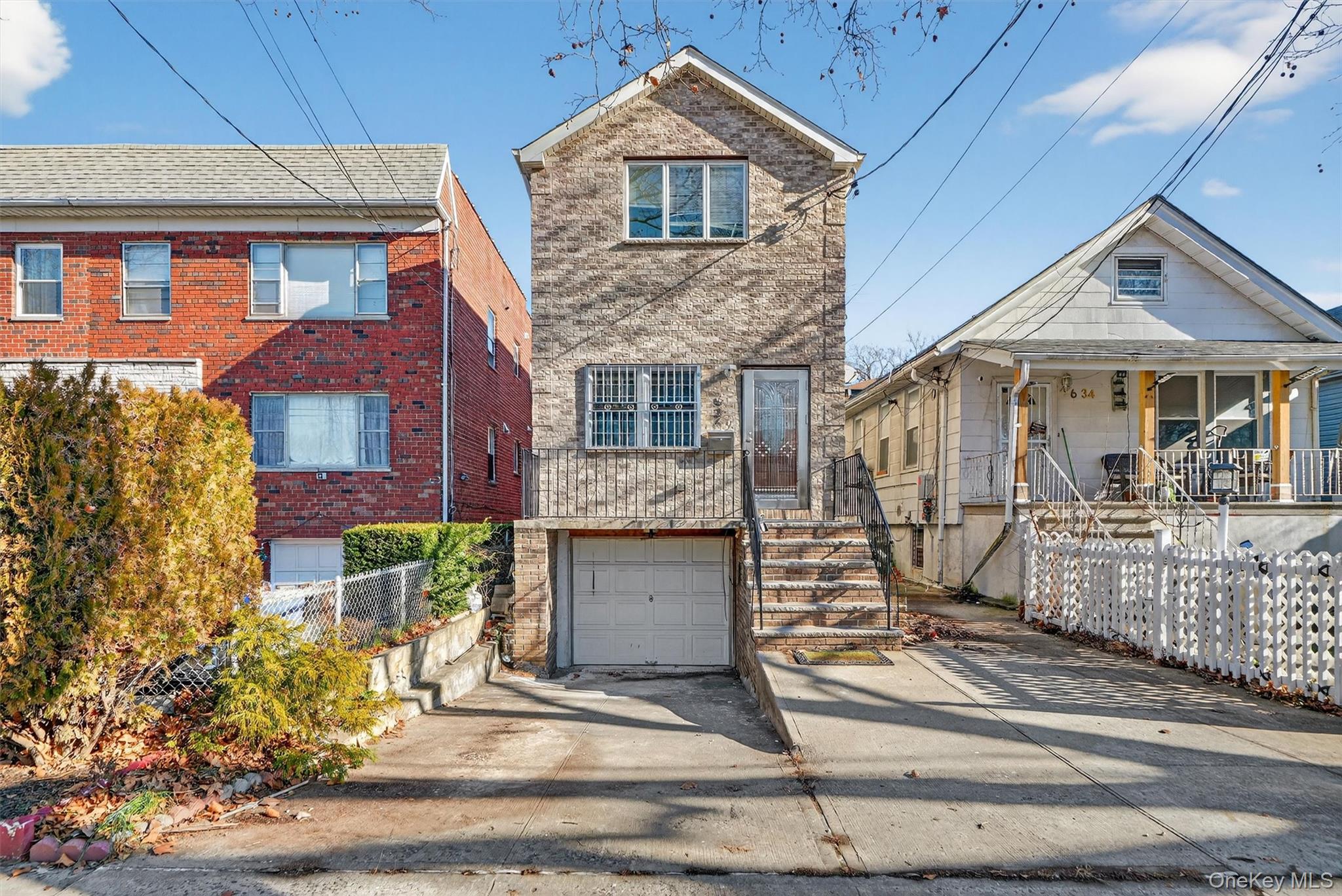 636 Throgs Neck Expressway Bronx, NY 10465 - Photo 2 of 31 View of front facade featuring concrete driveway, an attached garage, and brick siding