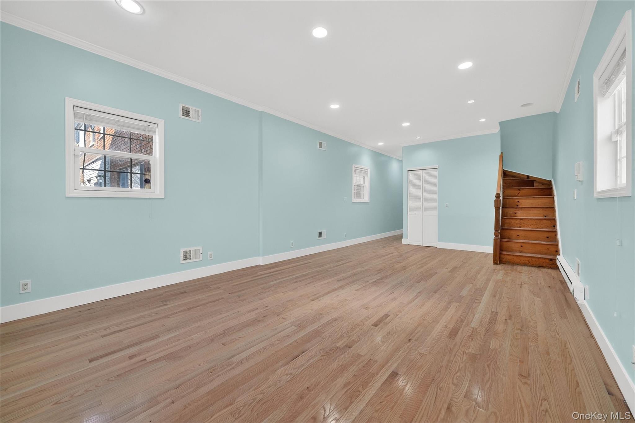 636 Throgs Neck Expressway Bronx, NY 10465 - Photo 3 of 31 Unfurnished room with recessed lighting, crown molding, stairs, light wood finished floors, and a baseboard radiator
