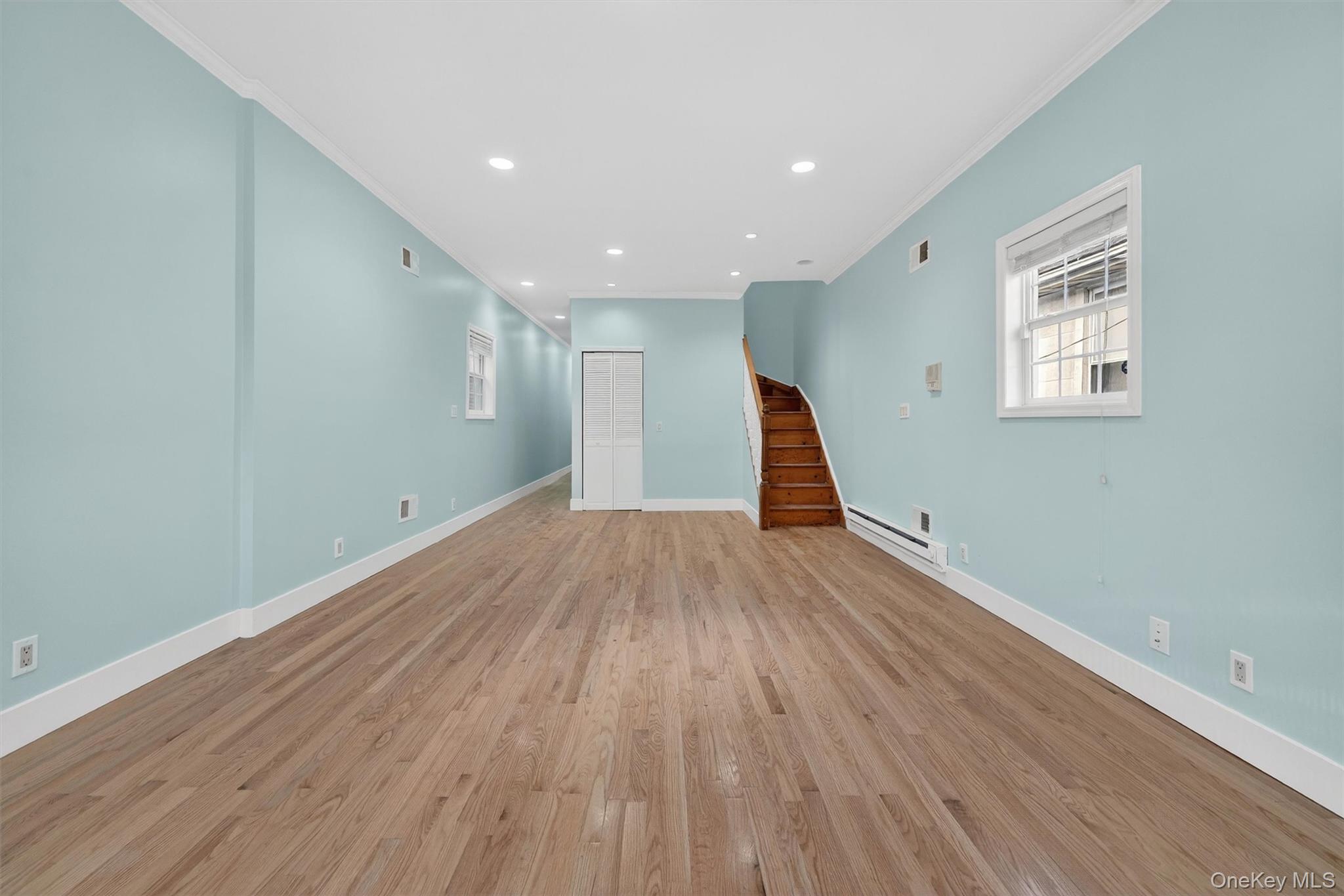 636 Throgs Neck Expressway Bronx, NY 10465 - Photo 4 of 31 Unfurnished living room with stairway, recessed lighting, light wood-style flooring, baseboard heating, and ornamental molding