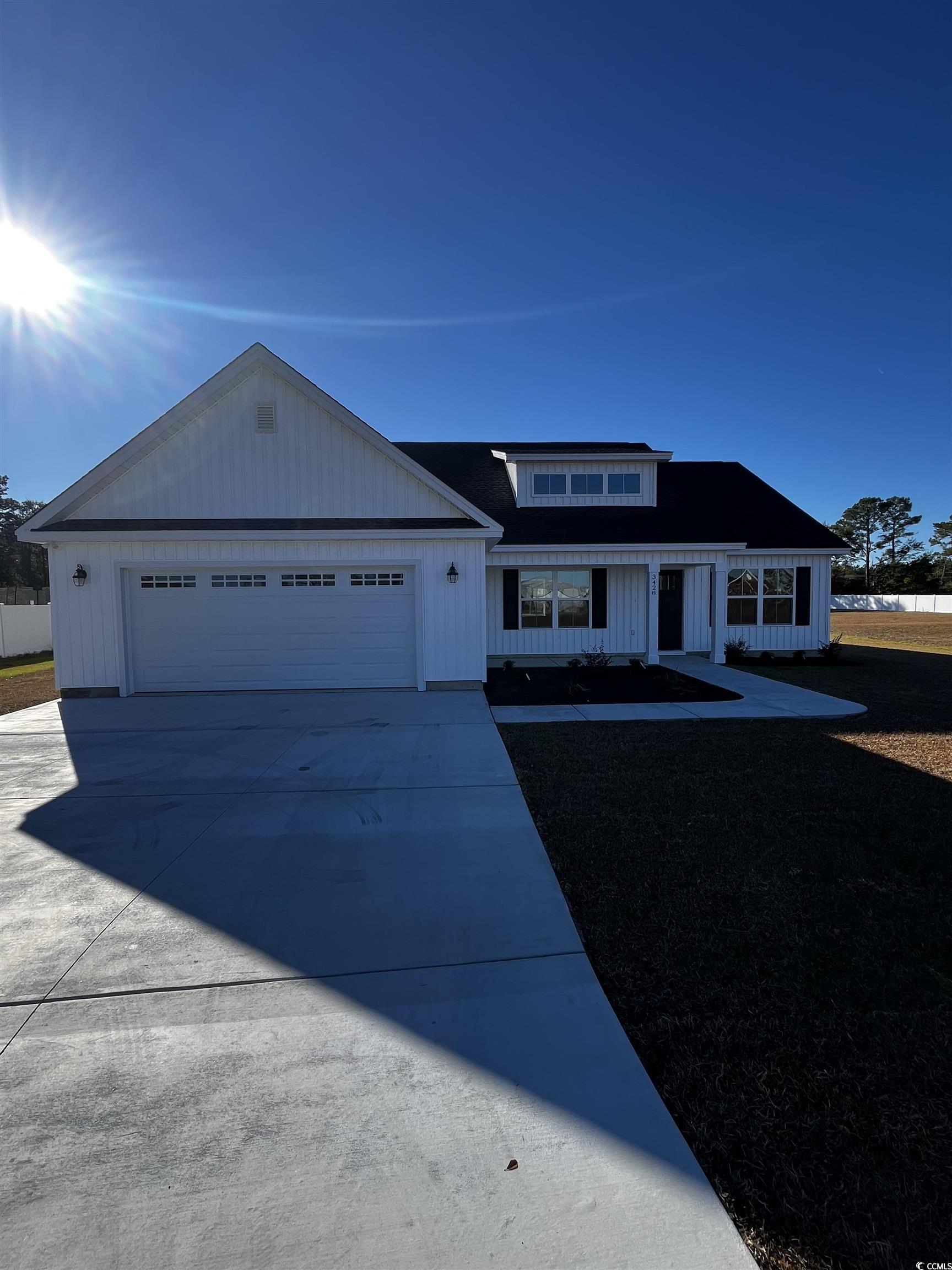 View of front of house featuring concrete driveway, an attached garage, and a front lawn