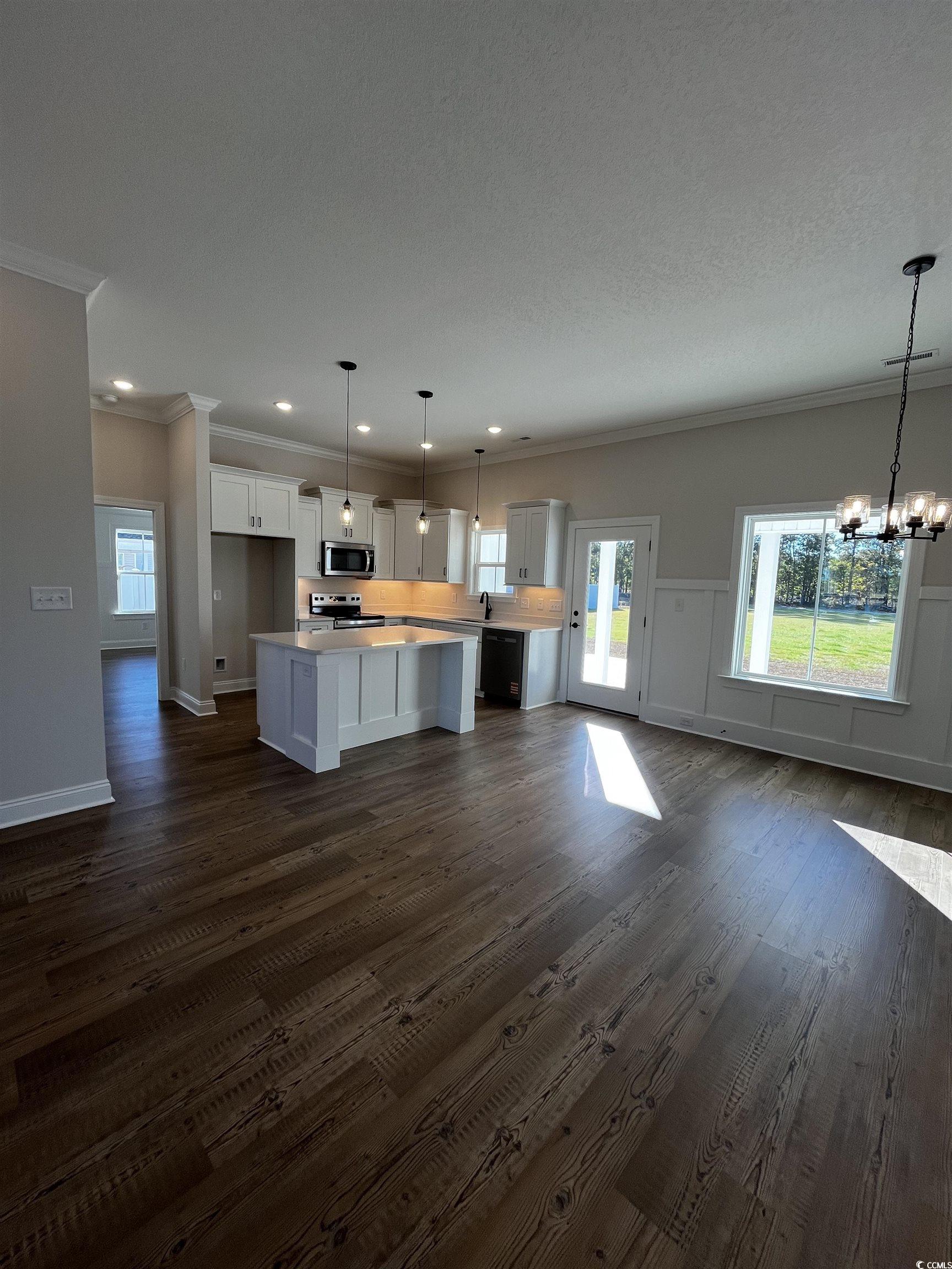 3428 Asbury Road Aynor, SC 29511 - Photo 10 of 10 Kitchen with open floor plan, a center island, dark wood-style floors, white cabinets, and crown molding