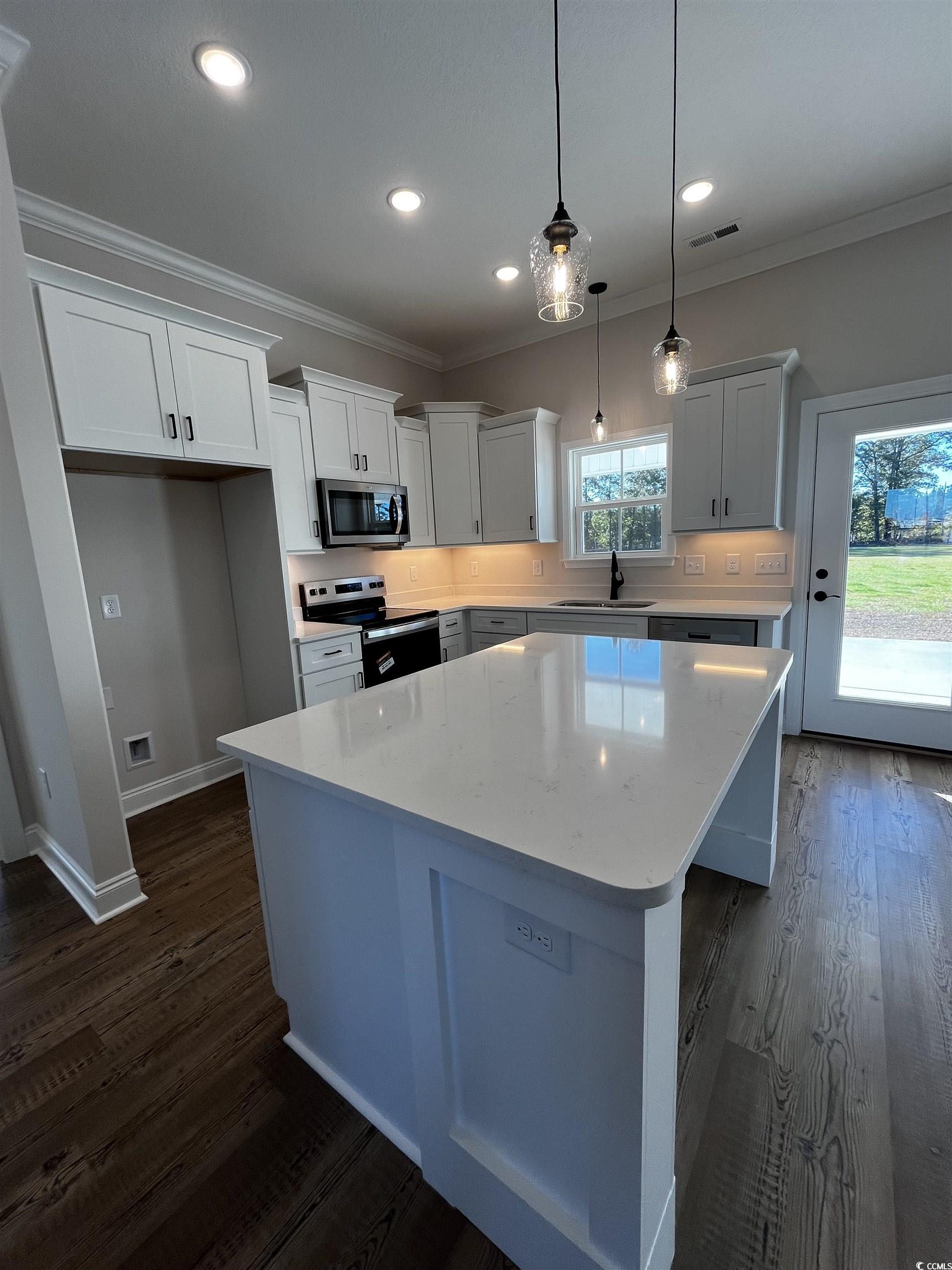 3428 Asbury Road Aynor, SC 29511 - Photo 4 of 10 Kitchen with crown molding, a kitchen island, white cabinetry, decorative light fixtures, and dark wood-style flooring