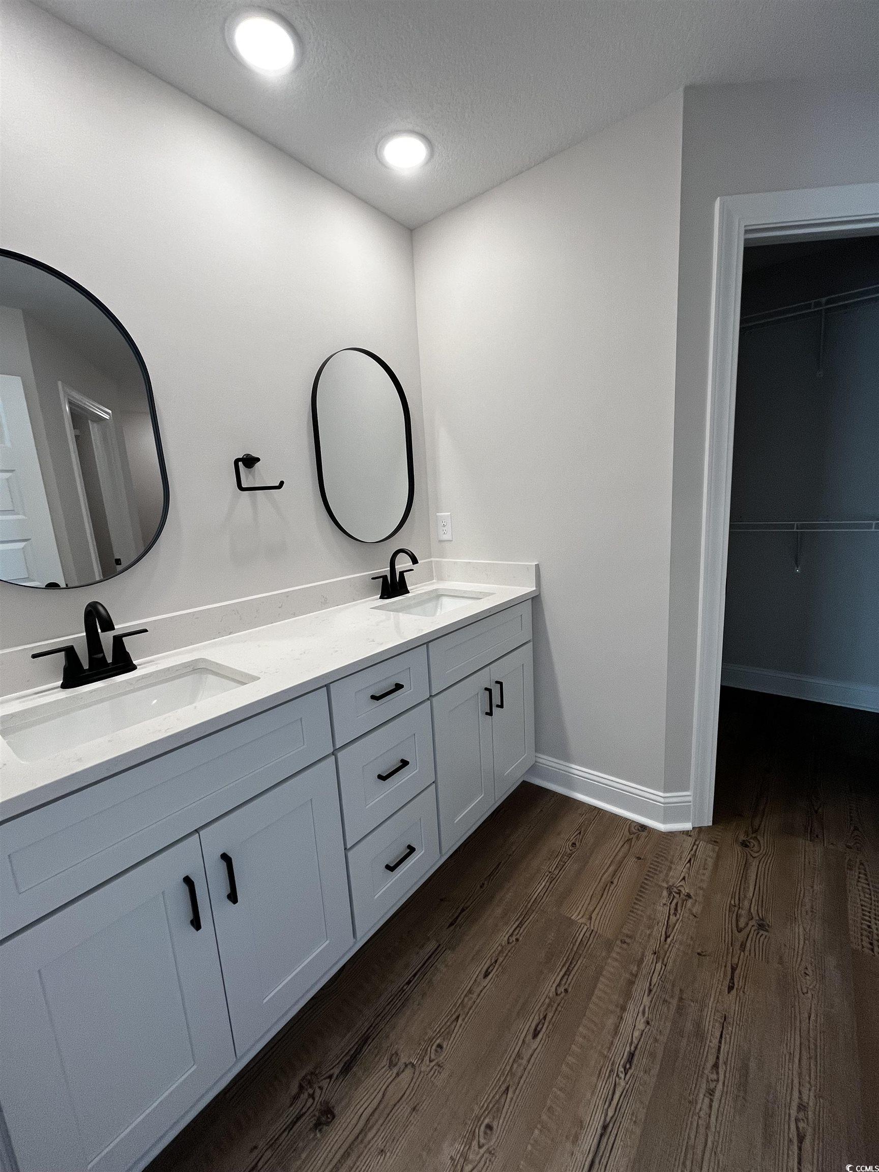 3428 Asbury Road Aynor, SC 29511 - Photo 6 of 10 Full bath featuring dark wood-style floors, double vanity, a spacious closet, a textured ceiling, and recessed lighting