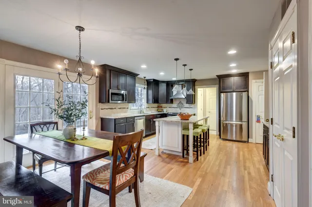 a large kitchen with stainless steel appliances granite countertop a stove a sink and a refrigerator