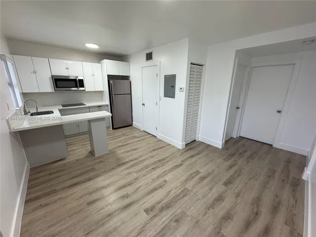 a kitchen with stainless steel appliances a refrigerator and a stove top oven