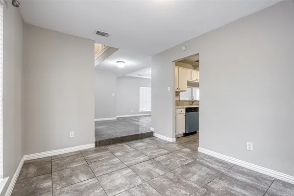 a view of an empty room and kitchen