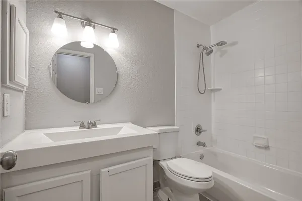 an empty room with wooden floor chandelier and windows