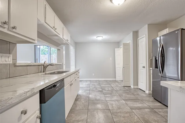 a view of a refrigerator in kitchen and white cabinets
