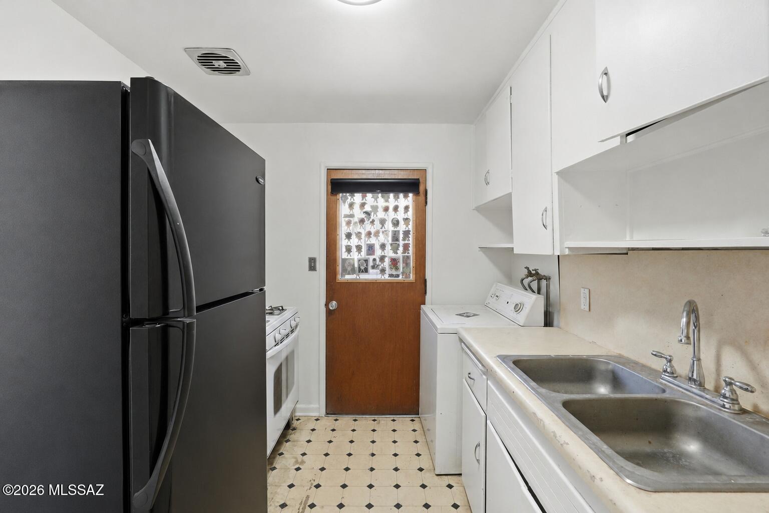 2721 East Fort Lowell Road Tucson, AZ 85716 - Photo 10 of 28 a kitchen with a sink a refrigerator and cabinets