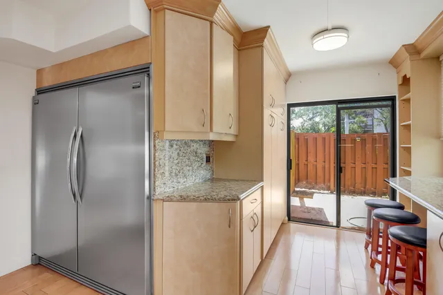 a kitchen with stainless steel appliances granite countertop a refrigerator and a stove top oven
