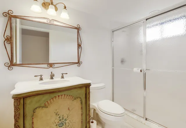 a bathroom with a toilet sink and mirror