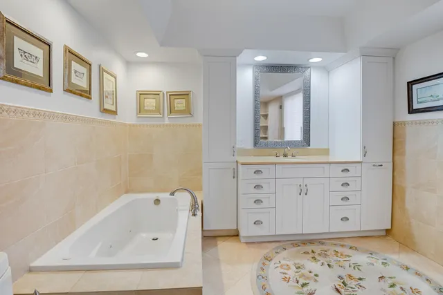 a bathroom with a bathtub sink and mirror