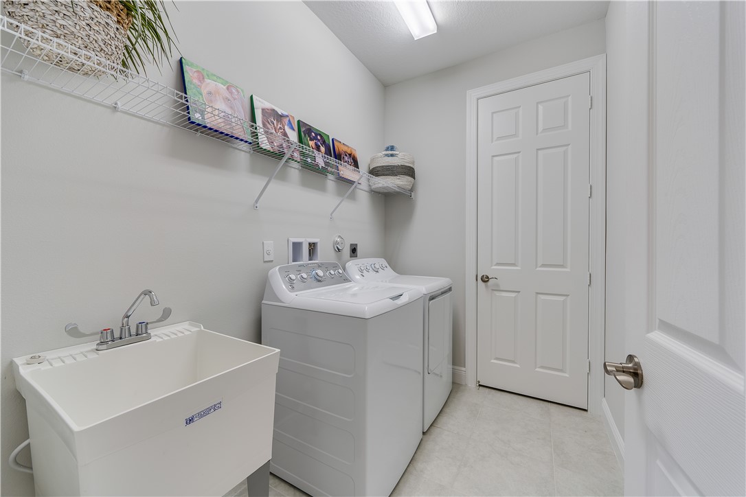 6145 Bella Rosa Lane Vero Beach, FL 32966 - Photo 6 of 8 a utility room with cabinets washer and dryer