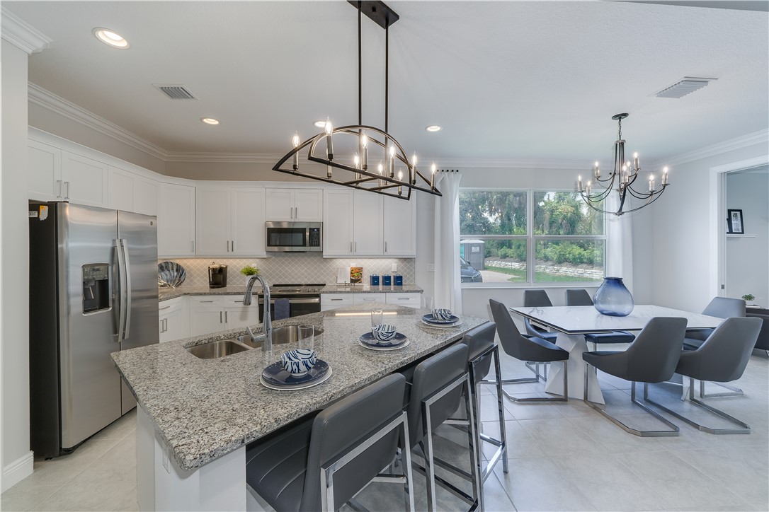 6145 Bella Rosa Lane Vero Beach, FL 32966 - Photo 7 of 8 a view of a dining room with furniture a chandelier and wooden floor