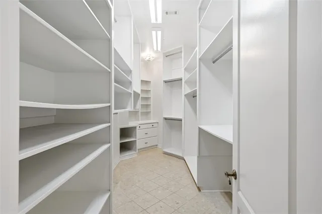 a view of walk in closet with empty racks