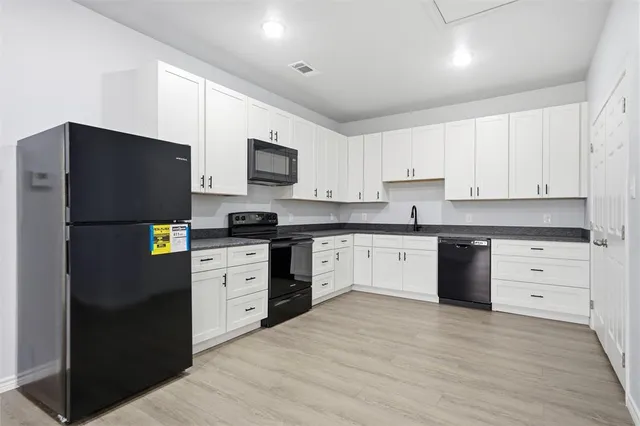 a kitchen with a refrigerator stove and white cabinets