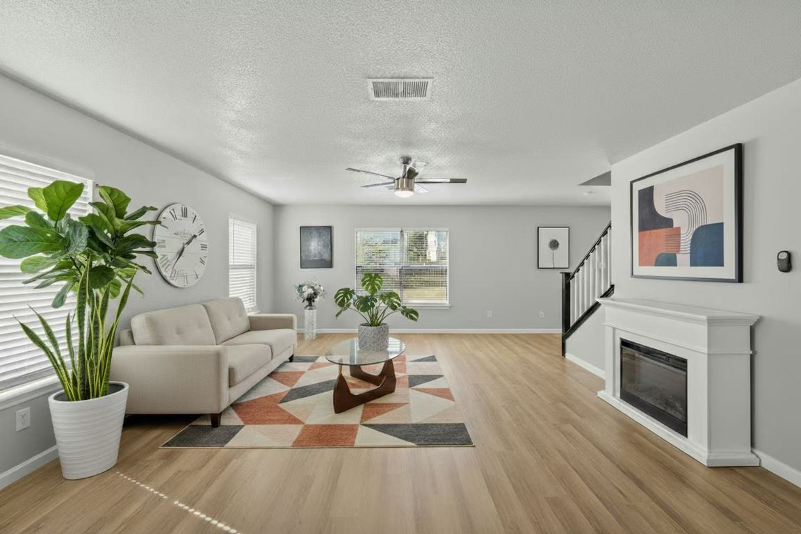 a living room with furniture a potted plant and a fireplace