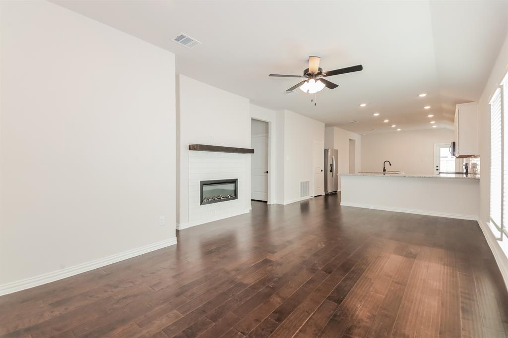 2610 Hawkins Street Anna, TX 75409 - Photo 3 of 17 Unfurnished living room with recessed lighting, a glass covered fireplace, dark wood-style flooring, and ceiling fan