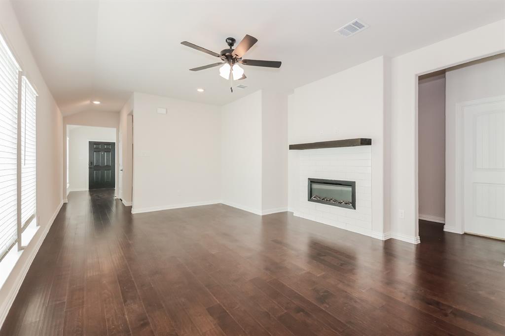 2610 Hawkins Street Anna, TX 75409 - Photo 6 of 17 Unfurnished living room featuring dark wood-type flooring, a glass covered fireplace, recessed lighting, a ceiling fan, and lofted ceiling