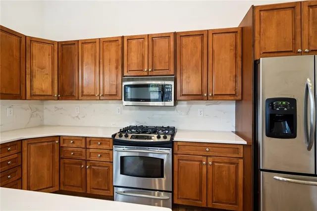 a kitchen with granite countertop a refrigerator stove and microwave