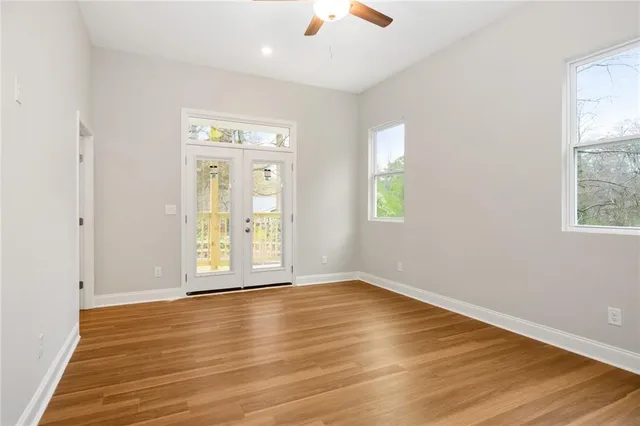 an empty room with wooden floor and windows