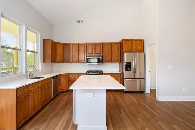 a kitchen with a refrigerator a sink and wooden cabinets