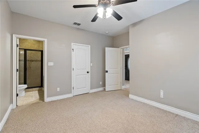 an empty room with chandelier fan