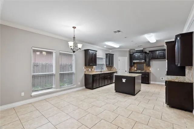 a large kitchen with a stove a sink dishwasher a refrigerator and a fireplace