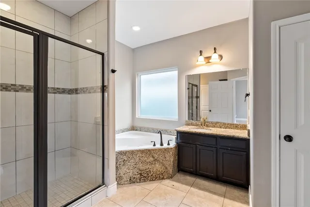 a bathroom with a tub a sink and mirror