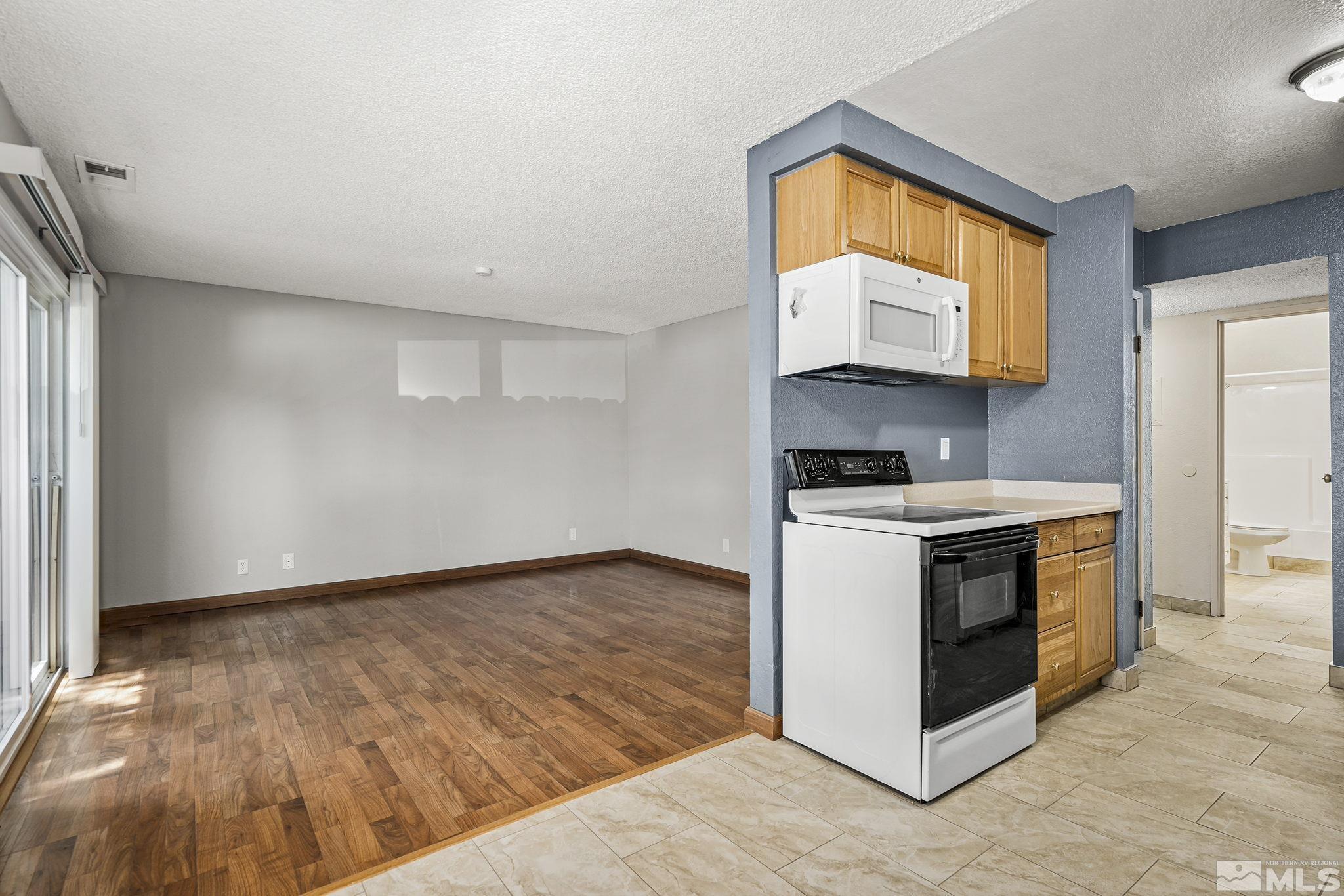 4600 Neil Road, Unit 3 Reno, NV 89502 - Photo 2 of 14 a kitchen with wooden floors and white appliances