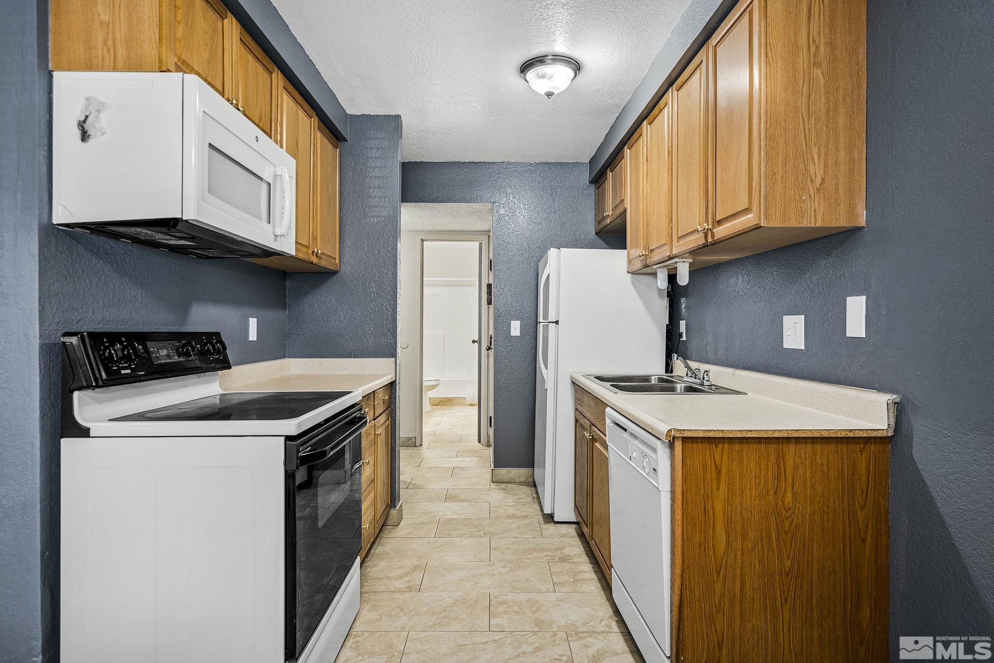 4600 Neil Road, Unit 3 Reno, NV 89502 - Photo 7 of 14 a kitchen with stainless steel appliances granite countertop a sink stove and refrigerator