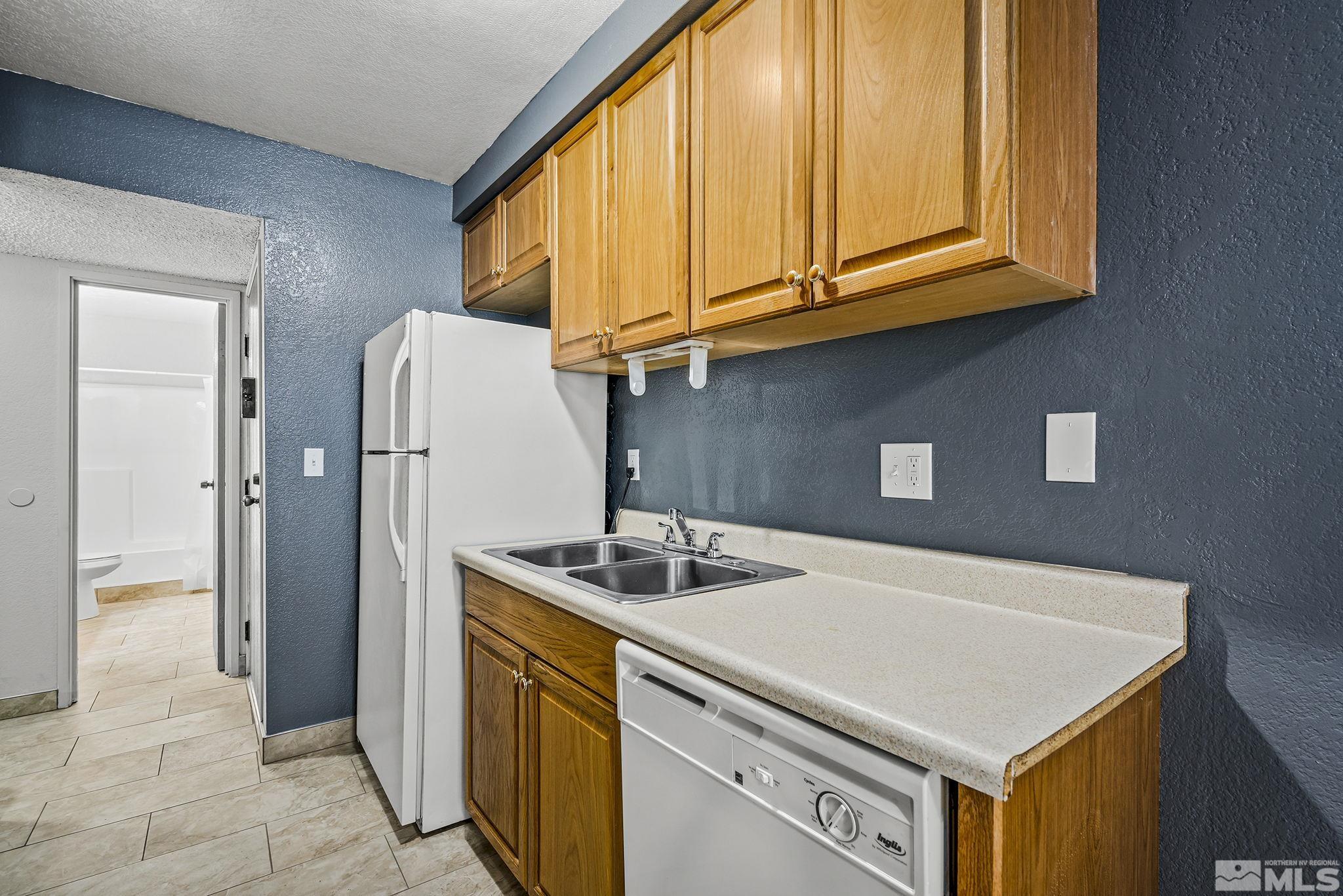 4600 Neil Road, Unit 3 Reno, NV 89502 - Photo 9 of 14 a kitchen with stainless steel appliances granite countertop a refrigerator sink and cabinets
