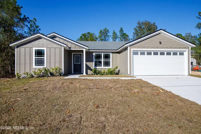 a view of a house with a yard and potted plants