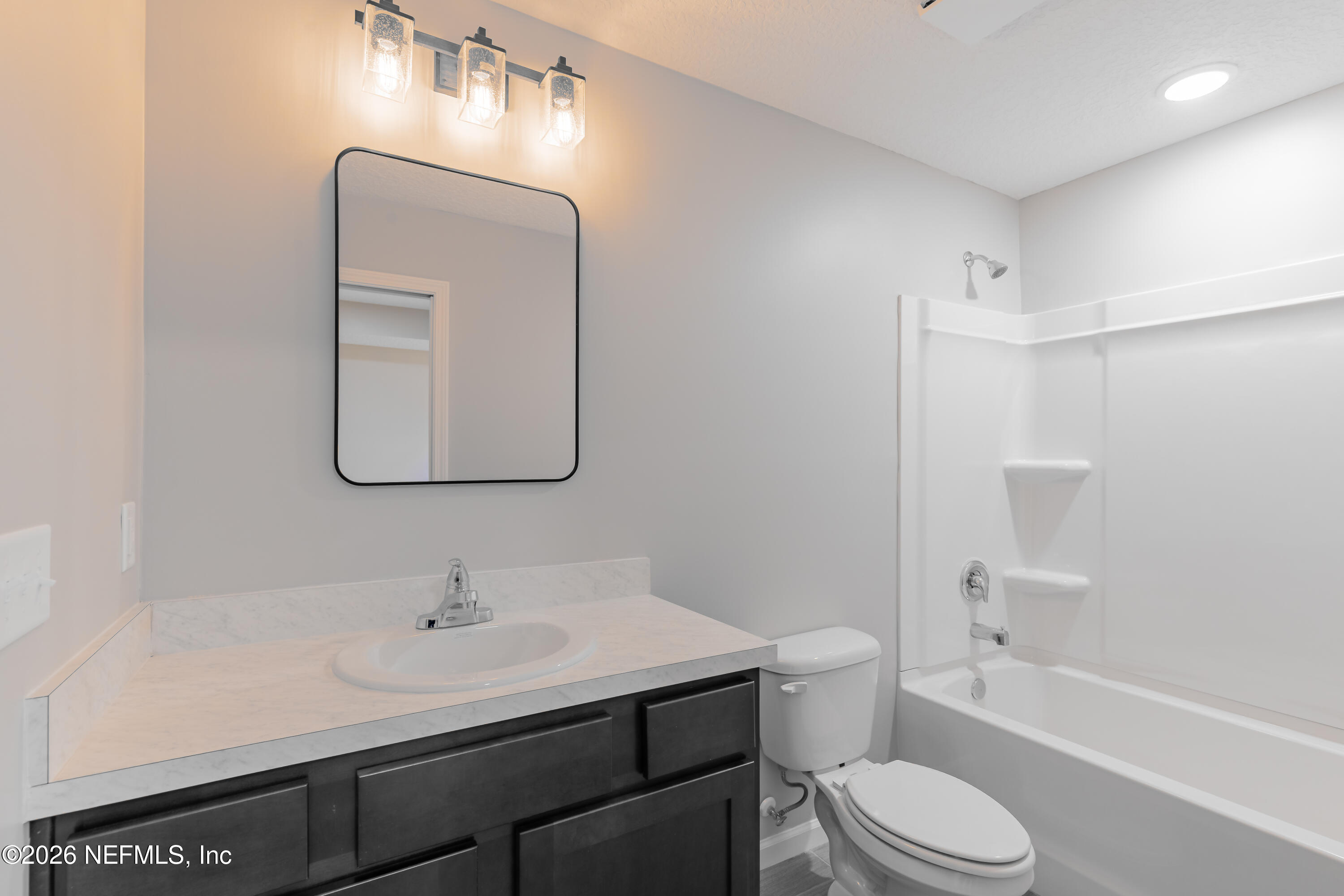 6330 Alliance Avenue Keystone Heights, FL 32656 - Photo 15 of 21 a bathroom with a toilet a sink a bathtub and a mirror