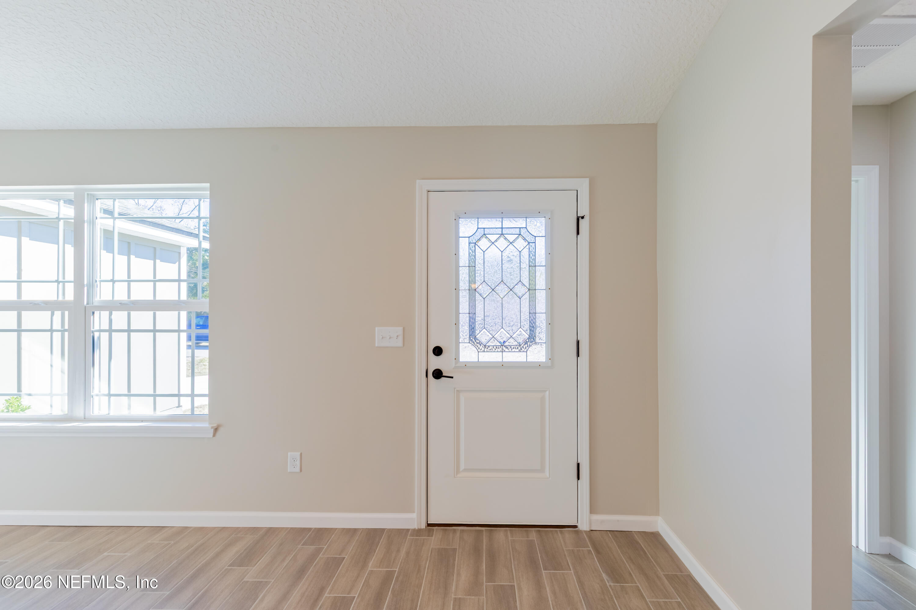6330 Alliance Avenue Keystone Heights, FL 32656 - Photo 4 of 21 an empty room with wooden floor and windows