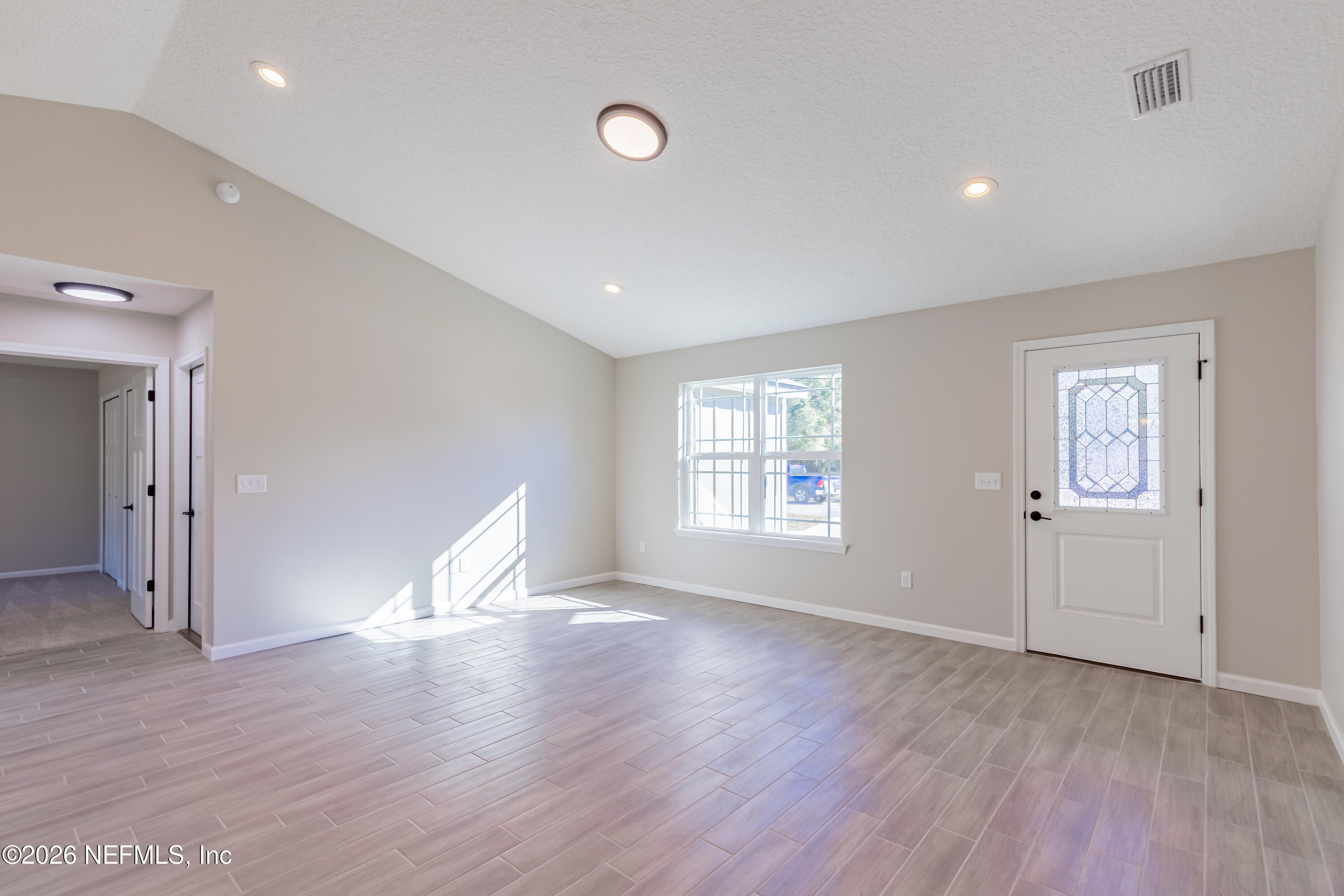 6330 Alliance Avenue Keystone Heights, FL 32656 - Photo 5 of 21 an empty room with wooden floor and windows