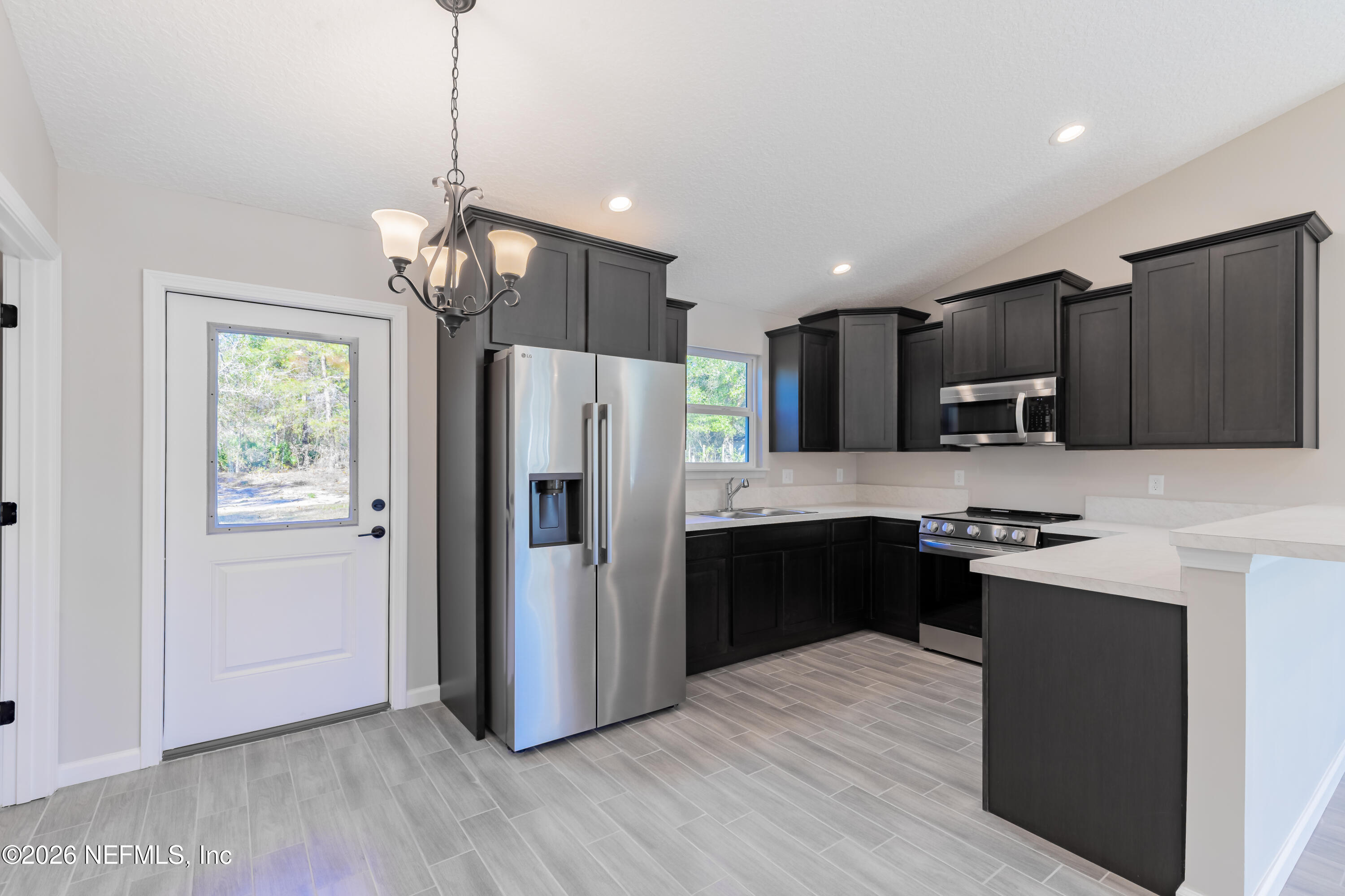 6330 Alliance Avenue Keystone Heights, FL 32656 - Photo 8 of 21 a kitchen with stainless steel appliances granite countertop a refrigerator a sink dishwasher a stove and white countertops with wooden floor