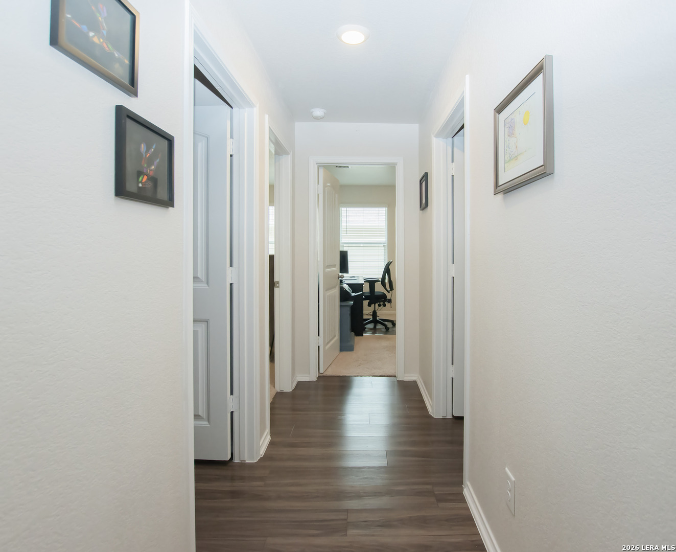 837 Indigo Way Seguin, TX 78155 - Photo 16 of 23 a view of a hallway with wooden floor and a flat screen tv