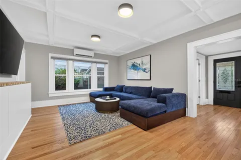 a living room with furniture a rug and a window